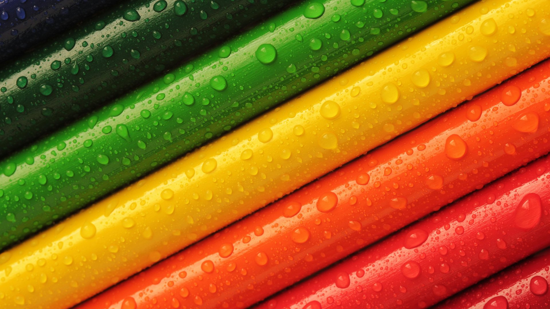 Farbige Stifte mit Wassertropfen, diagonal angeordnet.